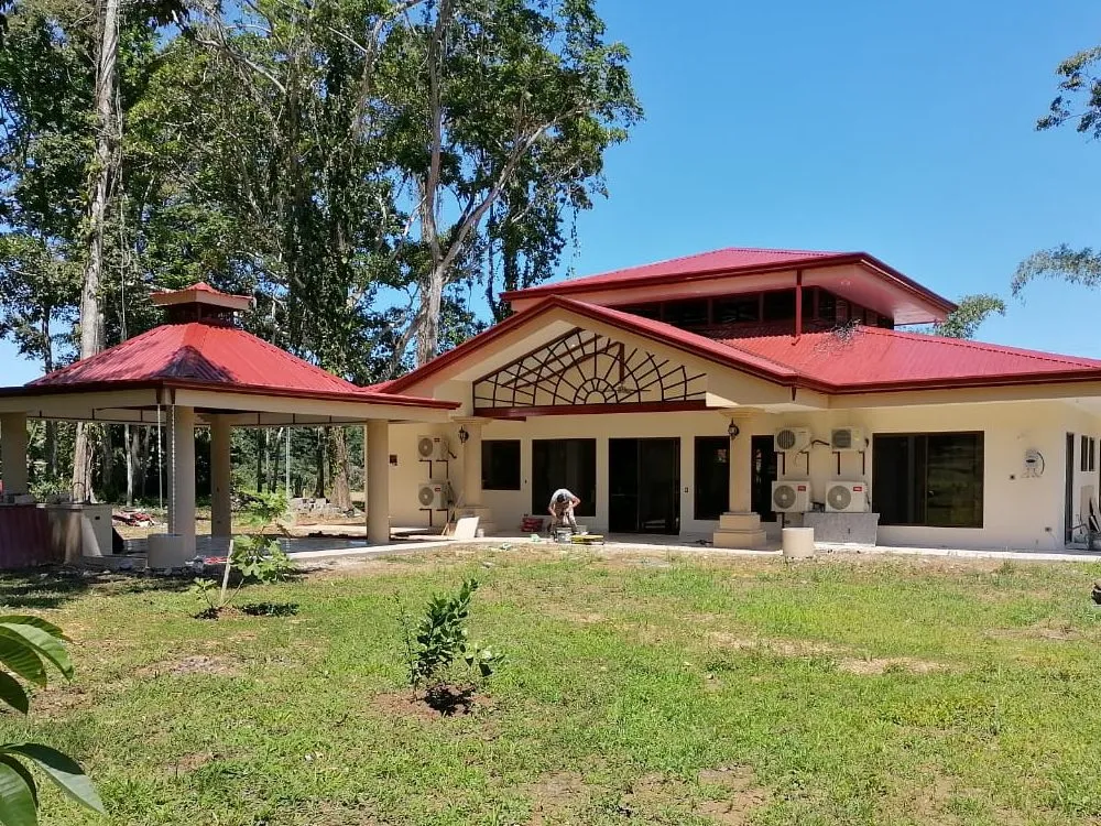 Casa de una planta terminada, con techo de teja y frontón decorativo